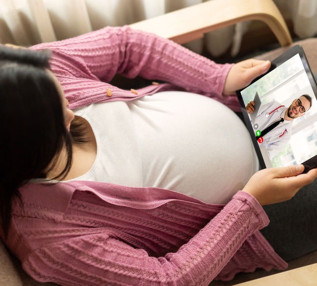 Doctor telemedicine service online video with pregnant woman for prenatal care . Remote doctor healthcare consultant from home using online mobile device connect to internet for live video call .